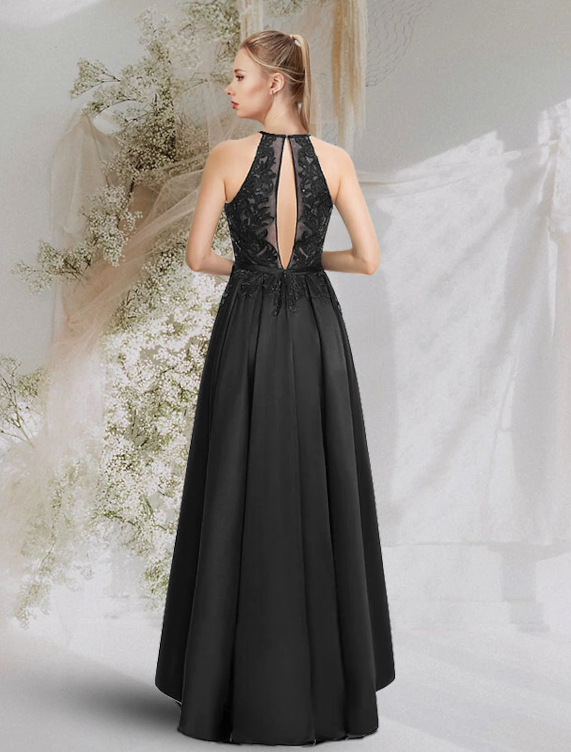 Model in A-line halter satin dress with backless design and asymmetrical hem.