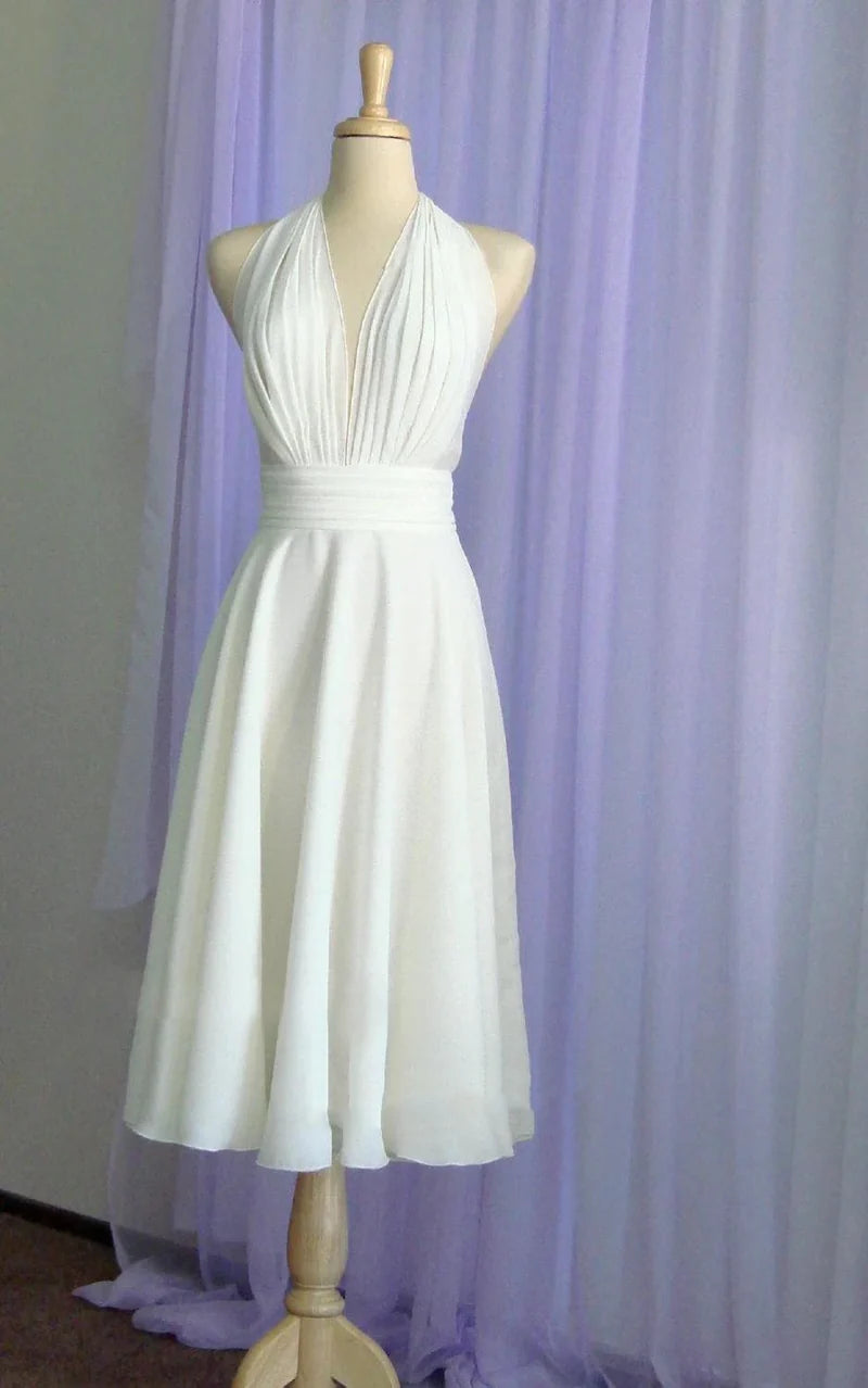 Tea-length chiffon wedding dress with halter neck and bow detail, front view.