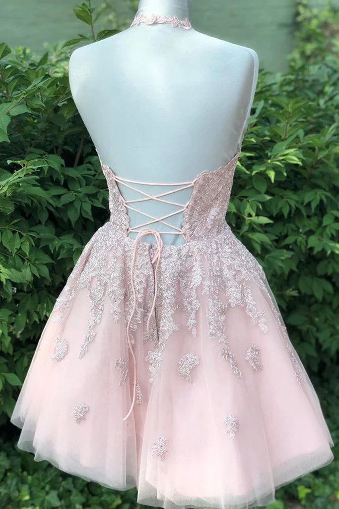 Back view of a woman in a light blue A-line halter neck short prom dress.