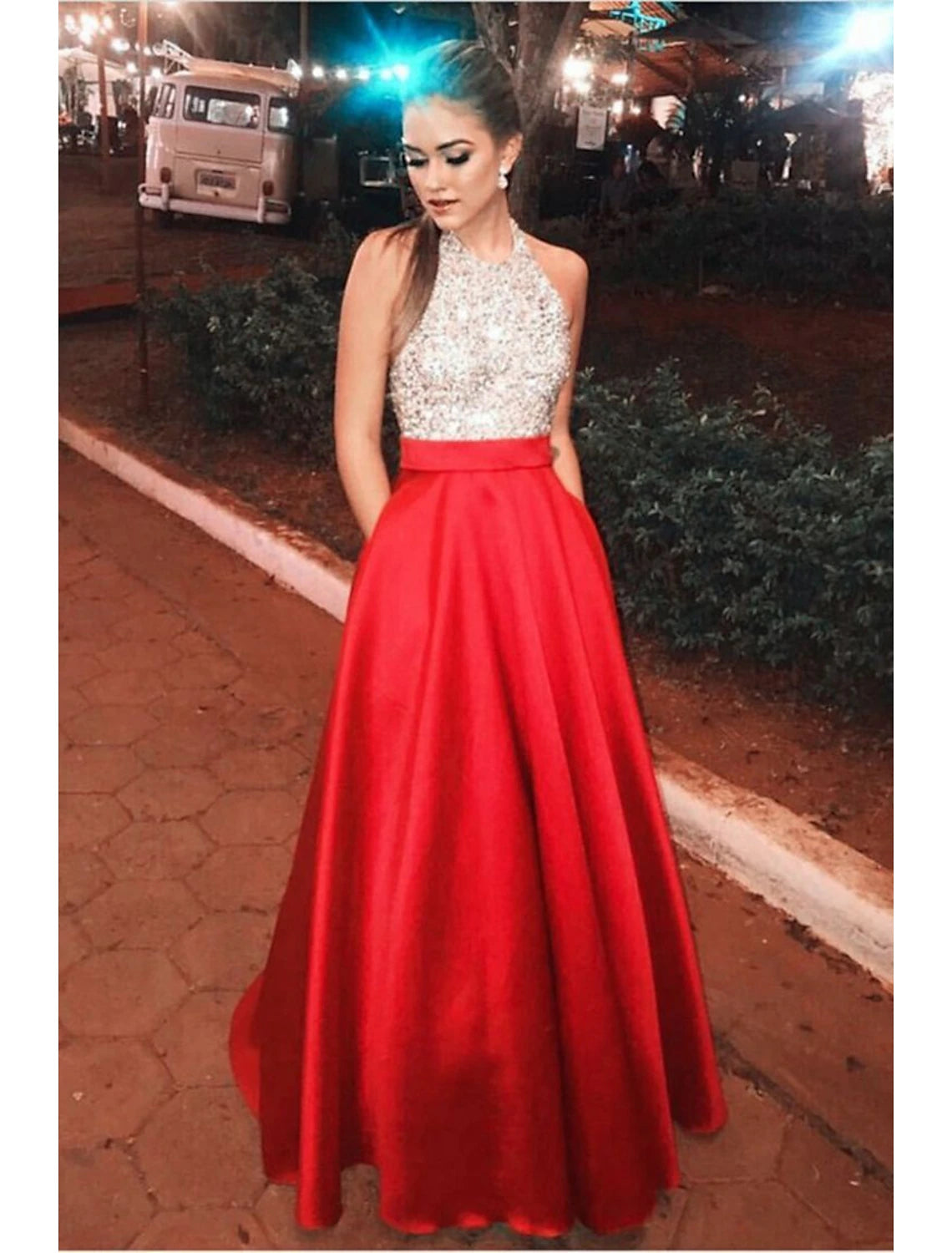 Woman wearing a color block A-line halter prom dress with sequin details.