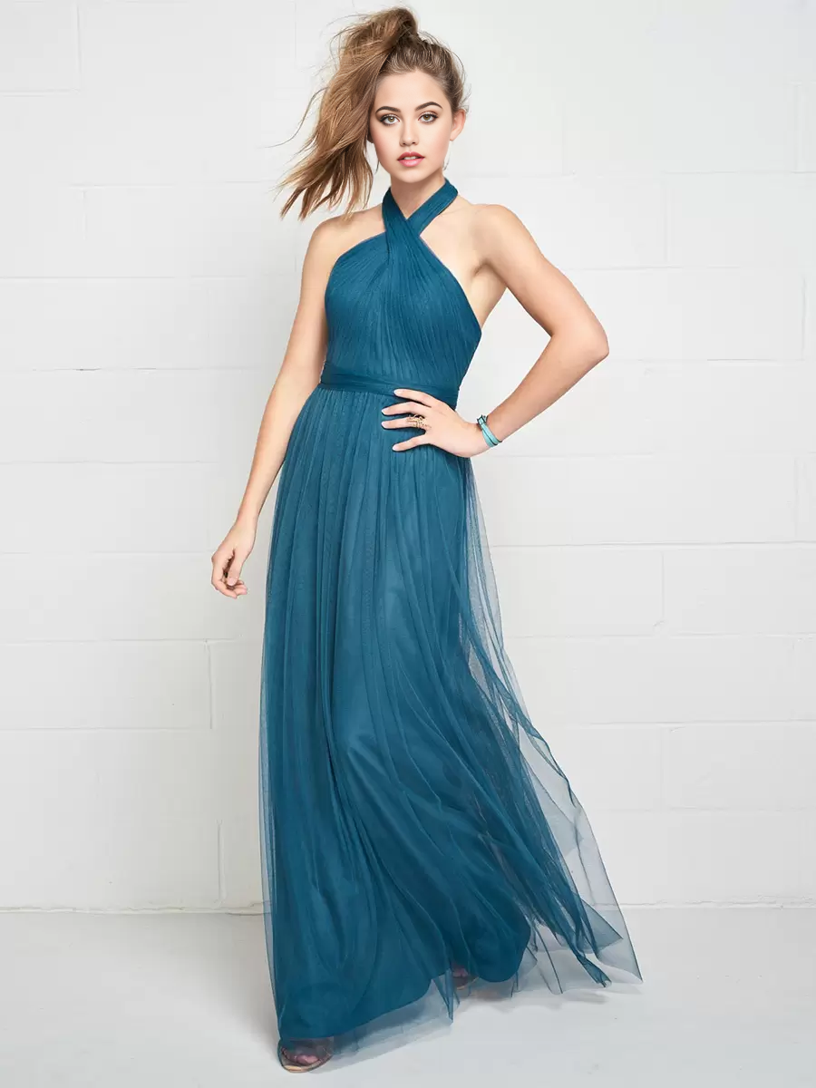Woman wearing an A-line halter ruched tulle dress with an open back.