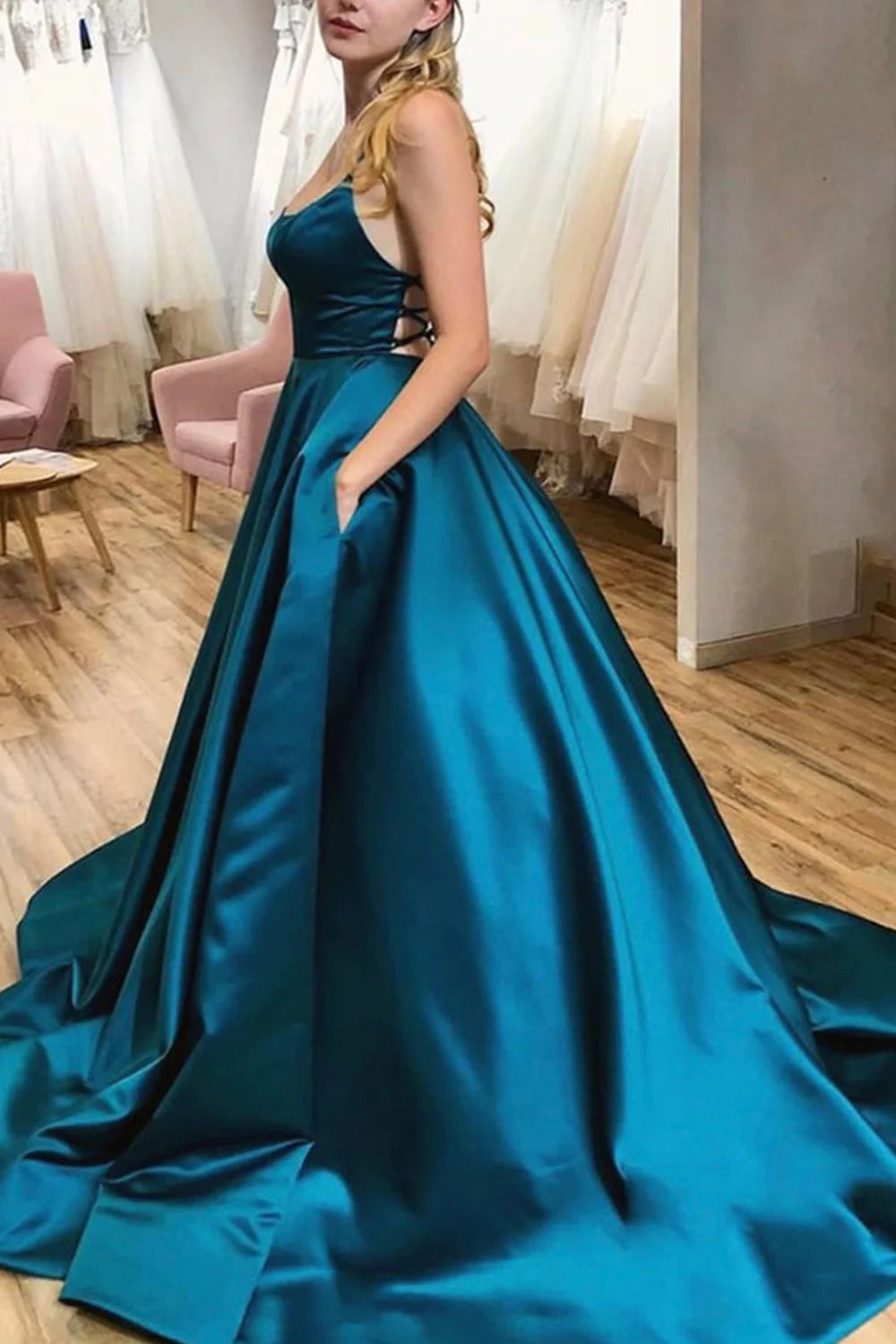 Back view of a peacock blue A-line halter satin long dress.