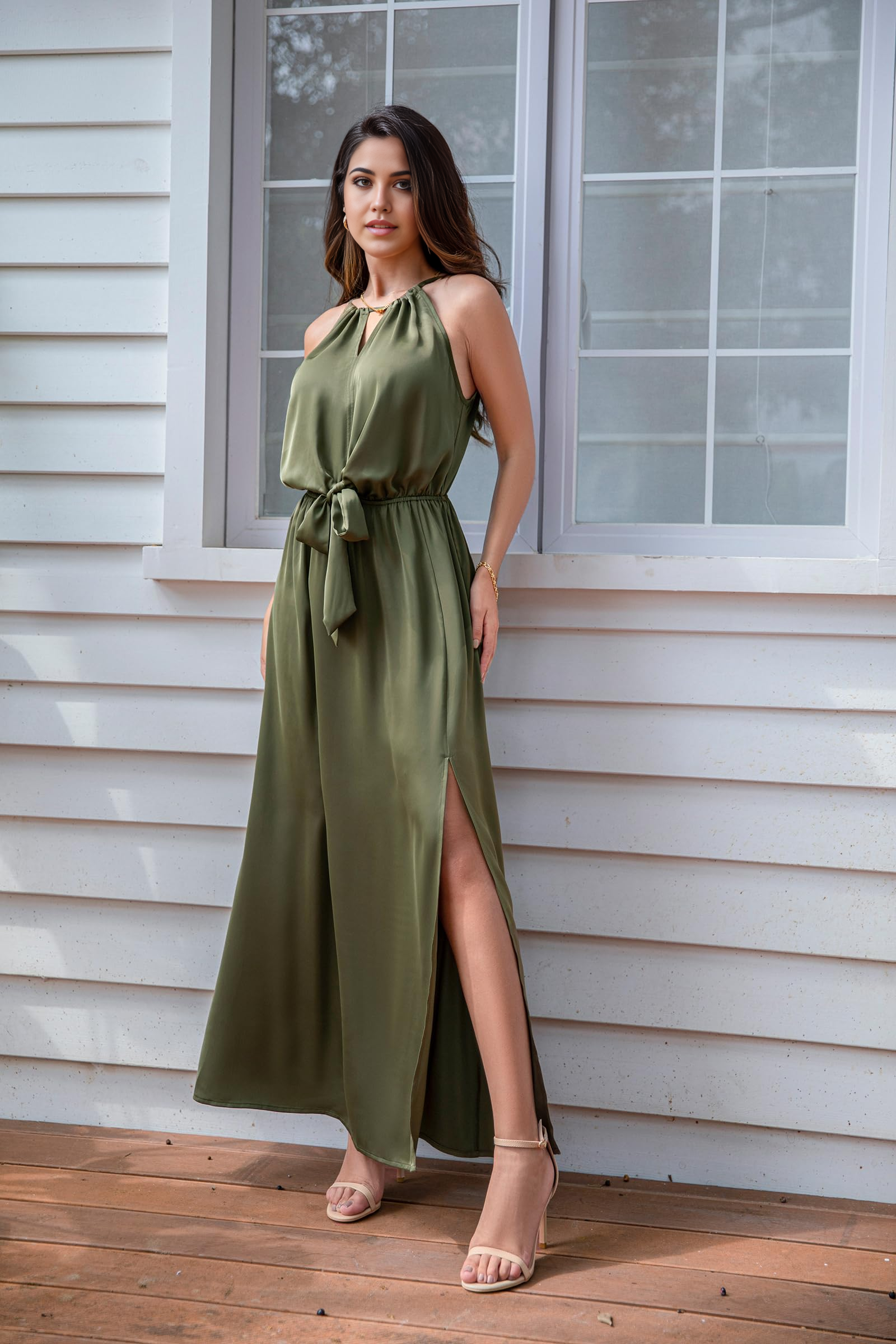 Woman wearing an elegant satin halter neck maxi dress with a high slit and tie waist.