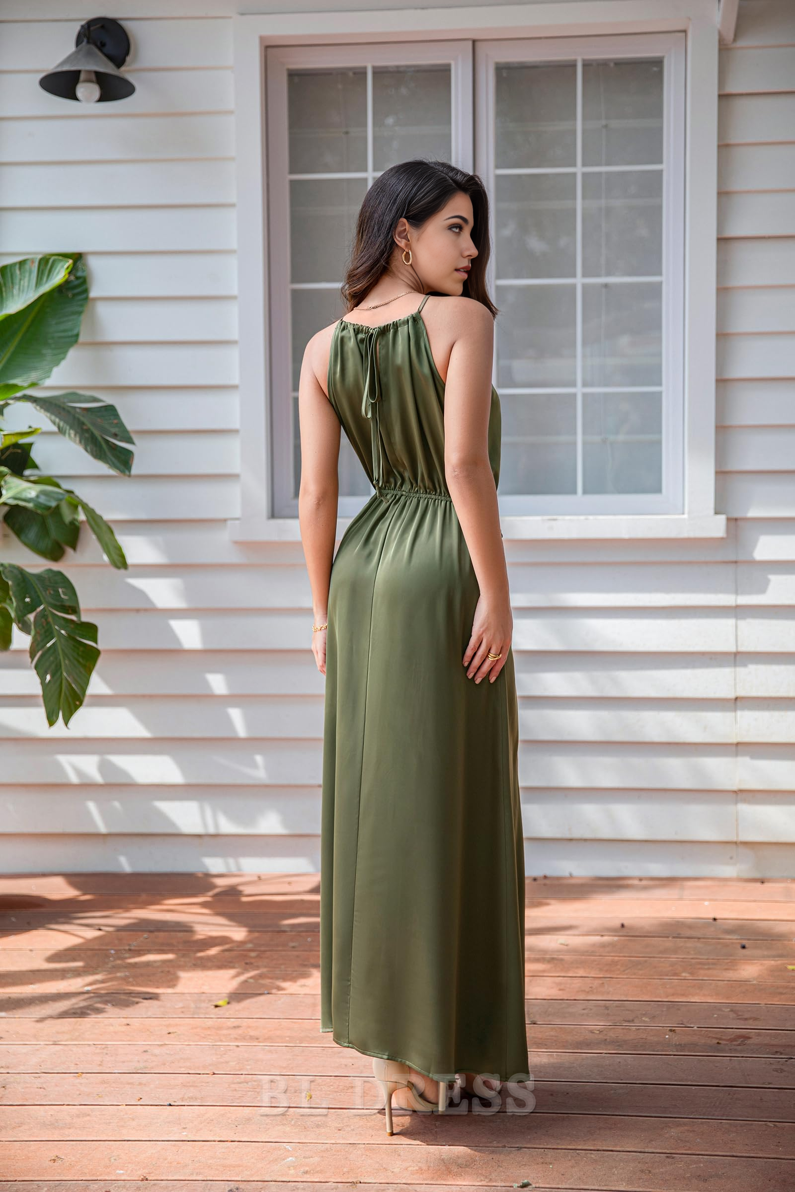 Back view of a woman in a satin halter neck maxi dress, showcasing the tie waist detail.