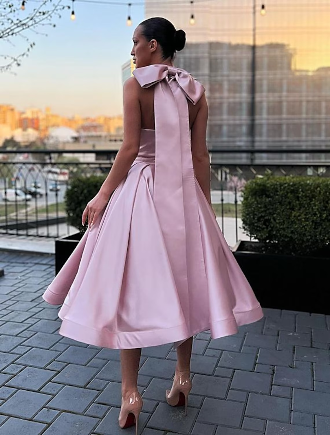 Model wearing an elegant A-line halter satin plus size evening gown with butterfly detail.