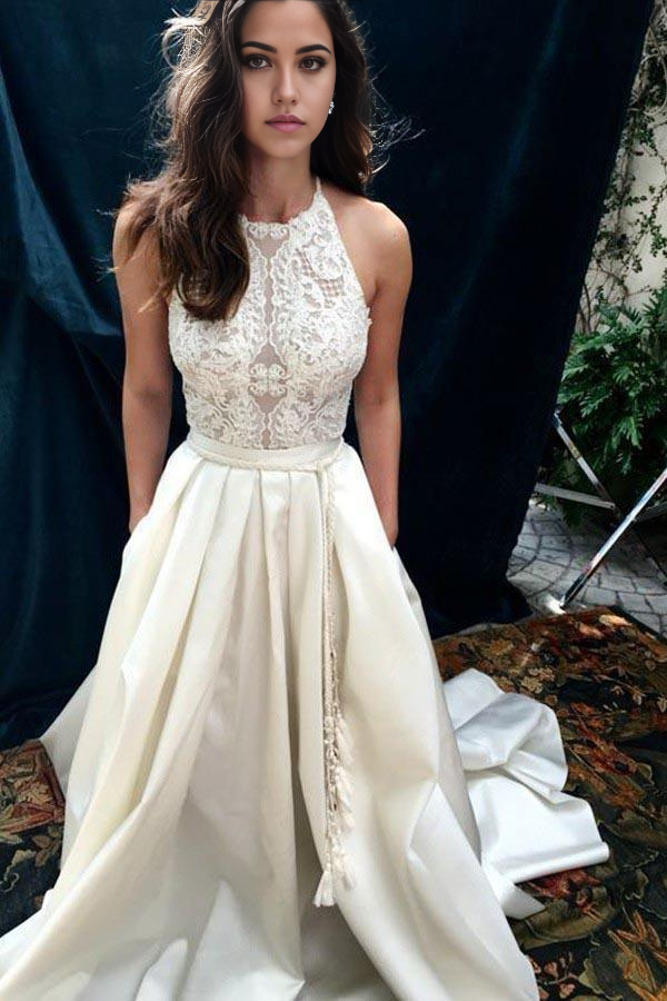 Ivory A-line wedding dress with halter neckline, lace details, and a sweep train.