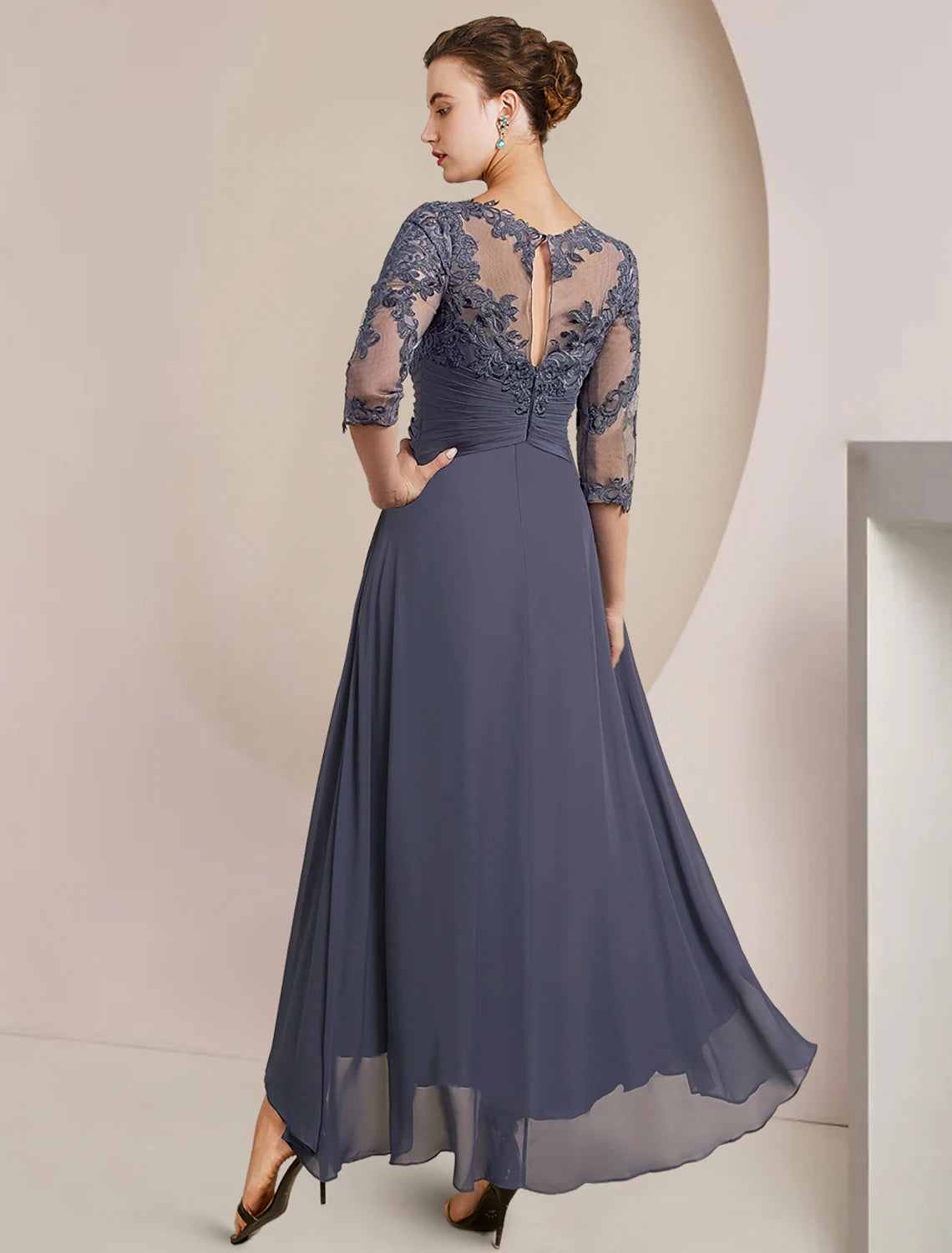 Back view of an elegant A-line high-low tea length mother of the bride dress with 3/4 sleeves and lace details.