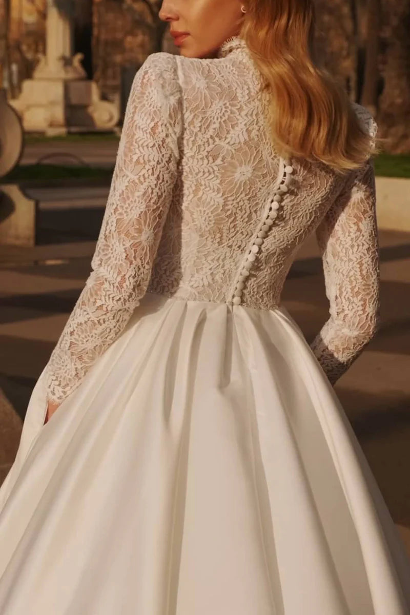 Close-up of lace detail on the long sleeve of a high neck wedding dress.