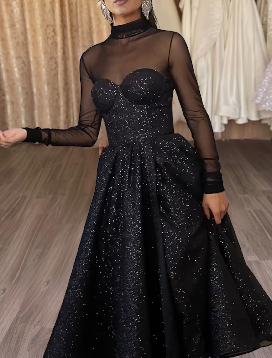 Black tea-length party dress featuring a high neckline, long sleeves, and sparkling tulle fabric.