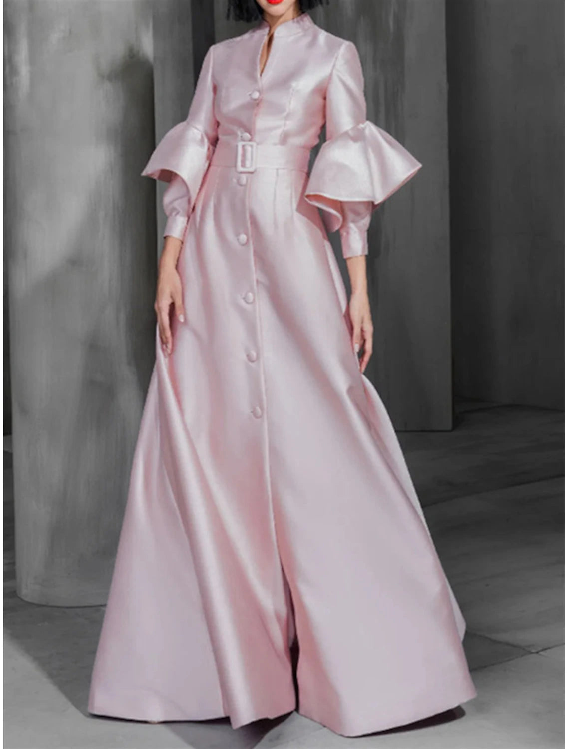 Side profile of the high neck long sleeve satin dress with a sash.
