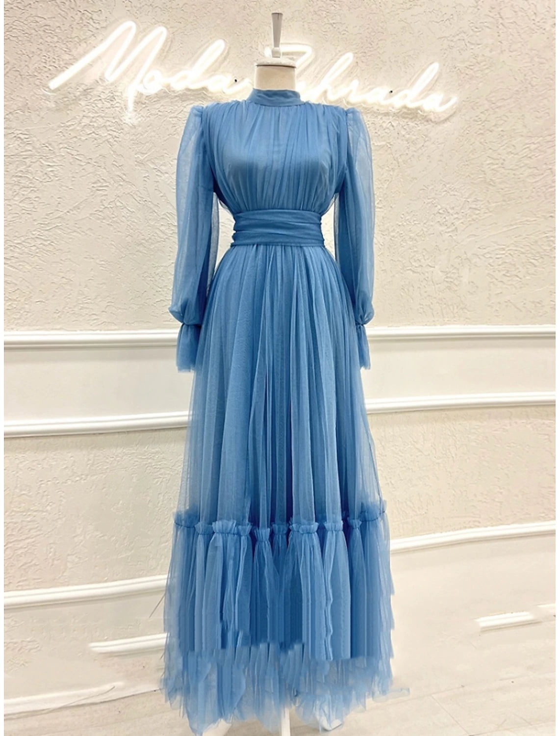 Side profile of the long sleeve high neck gown.
