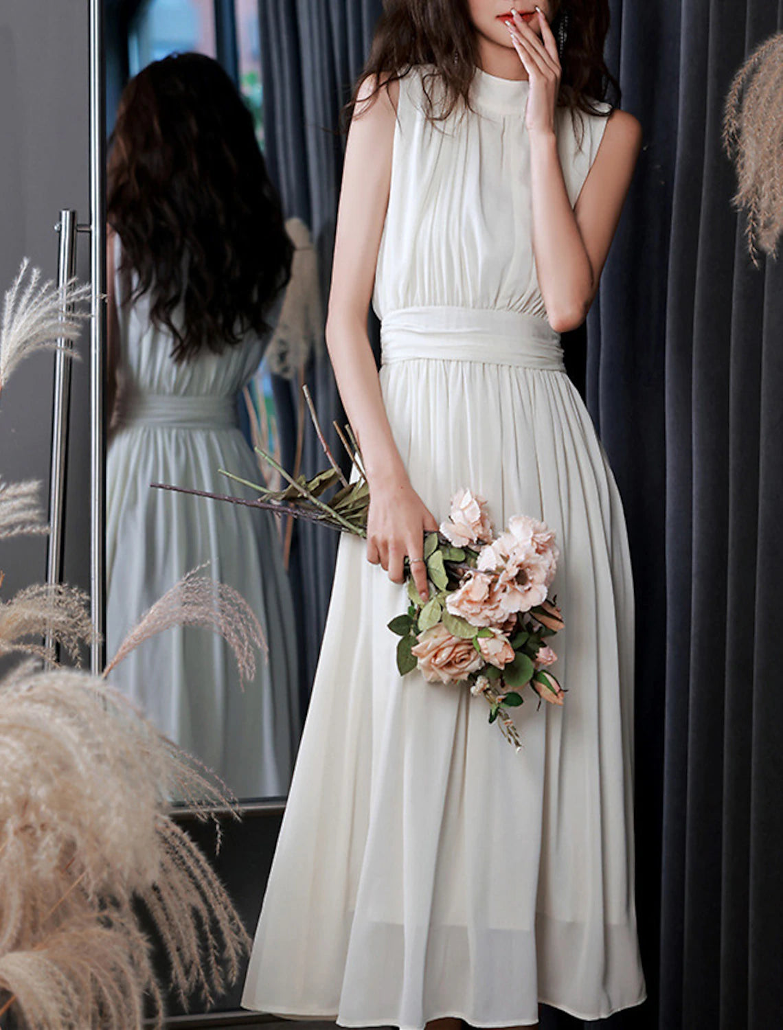 White A-line chiffon dress with a flowing tea length skirt and elegant pleats.