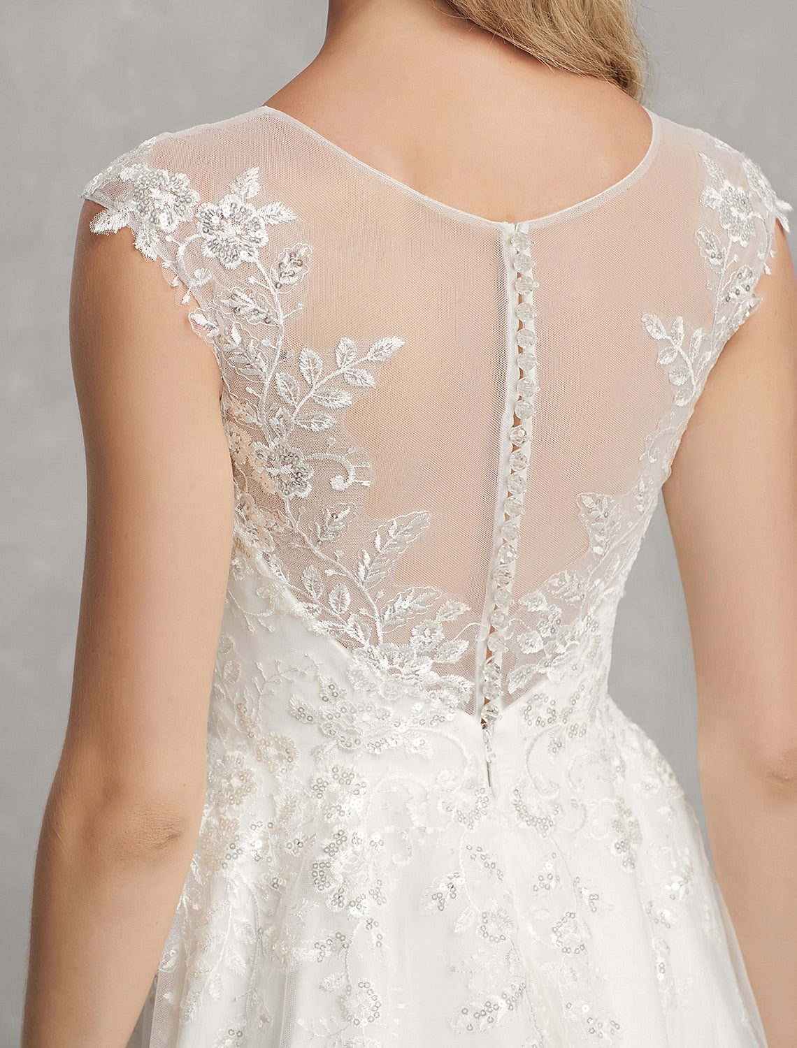 Back view of a white A-line dress, showing the elegant silhouette and lace appliques.