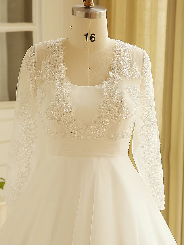 Bride posing in a flowing A-line wedding dress with a court train.