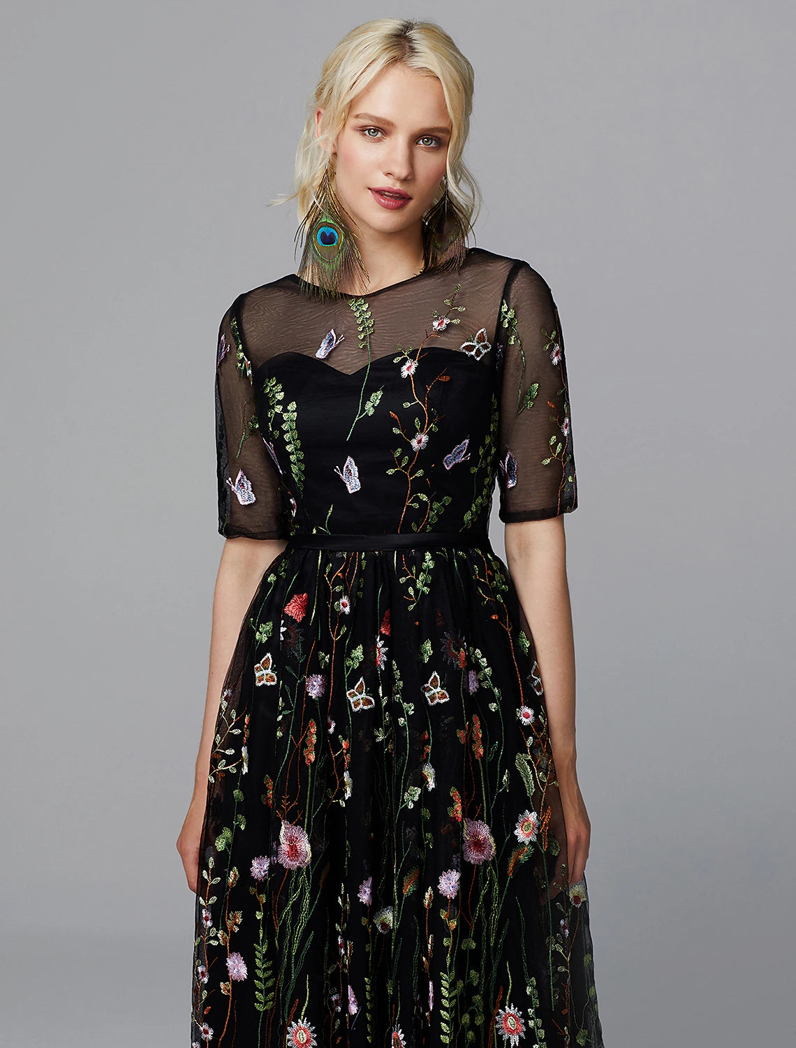 Close-up of intricate floral lace and embroidery appliques on tea length dress.