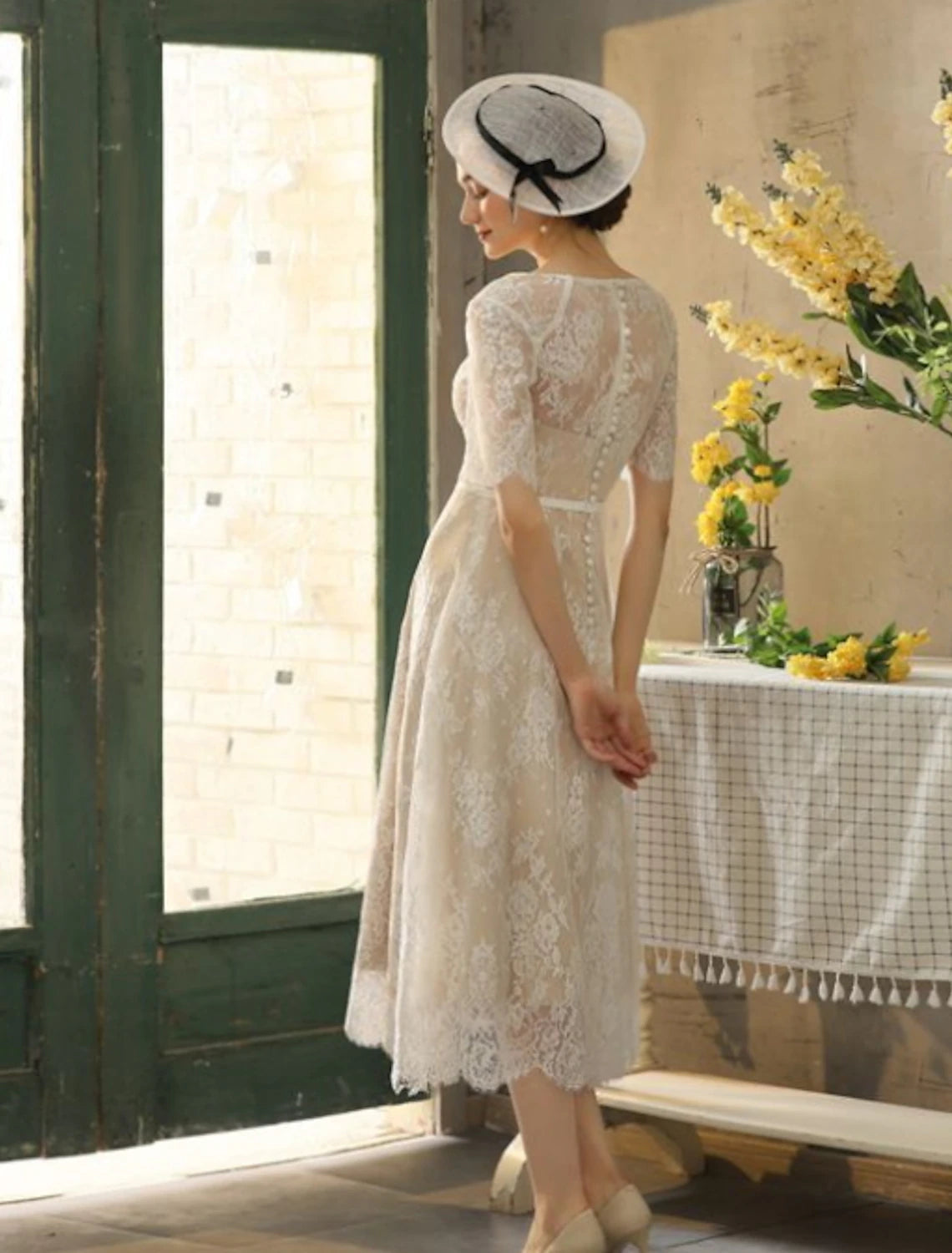 Full view of the tea-length white dress, ideal for summer parties.
