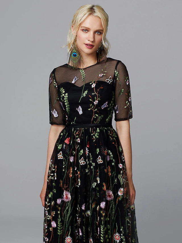 Close-up of white A-line dress showing illusion neckline and lace embroidery.