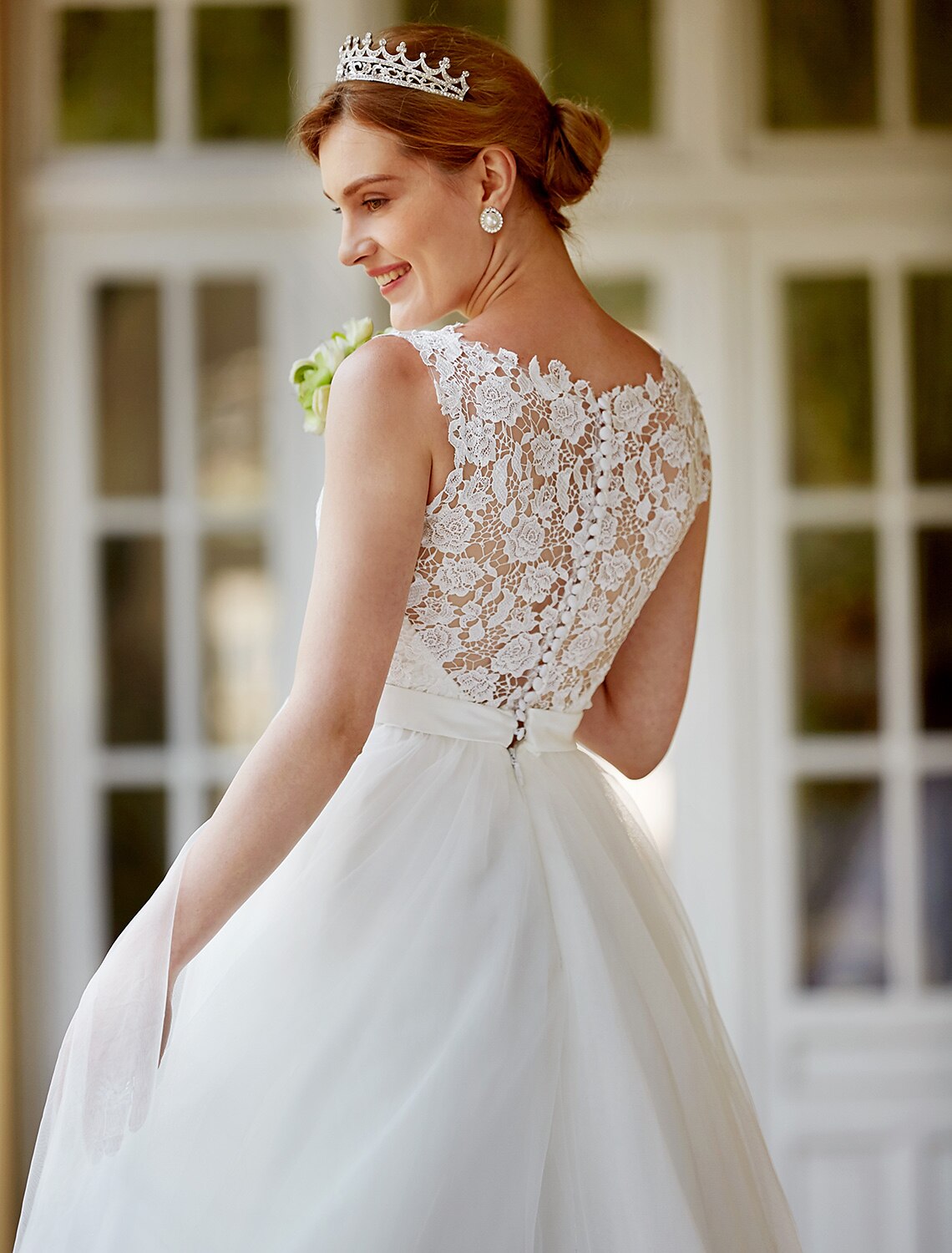 Full length view of a white A-line tea length lace dress for receptions.