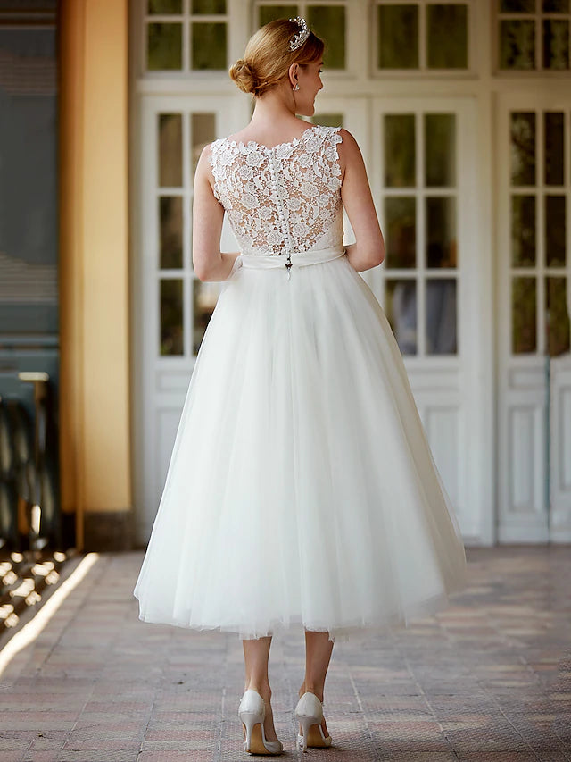 Close-up of the delicate lace and illusion neckline on the white wedding dress.