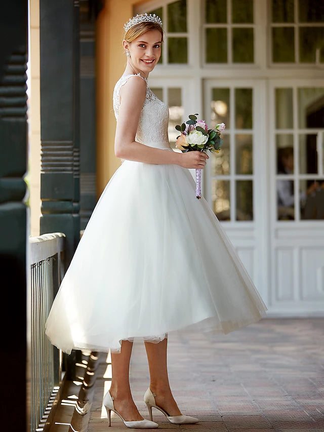 Back view of the white tea length wedding dress, showing button details and sashes.