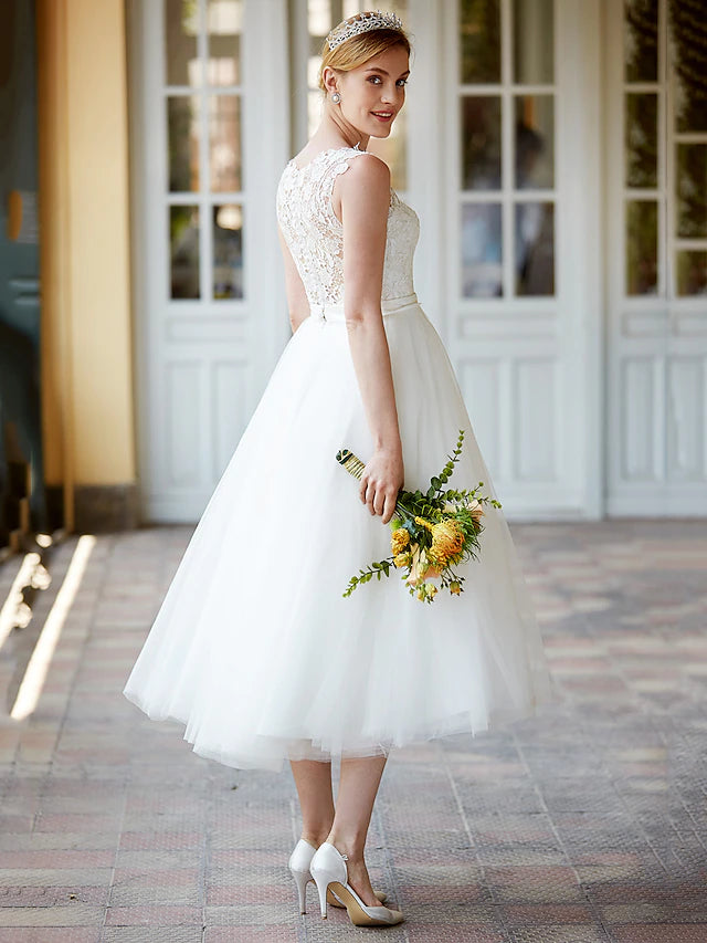 Model wearing the white lace wedding dress, showcasing its tea length and flow.