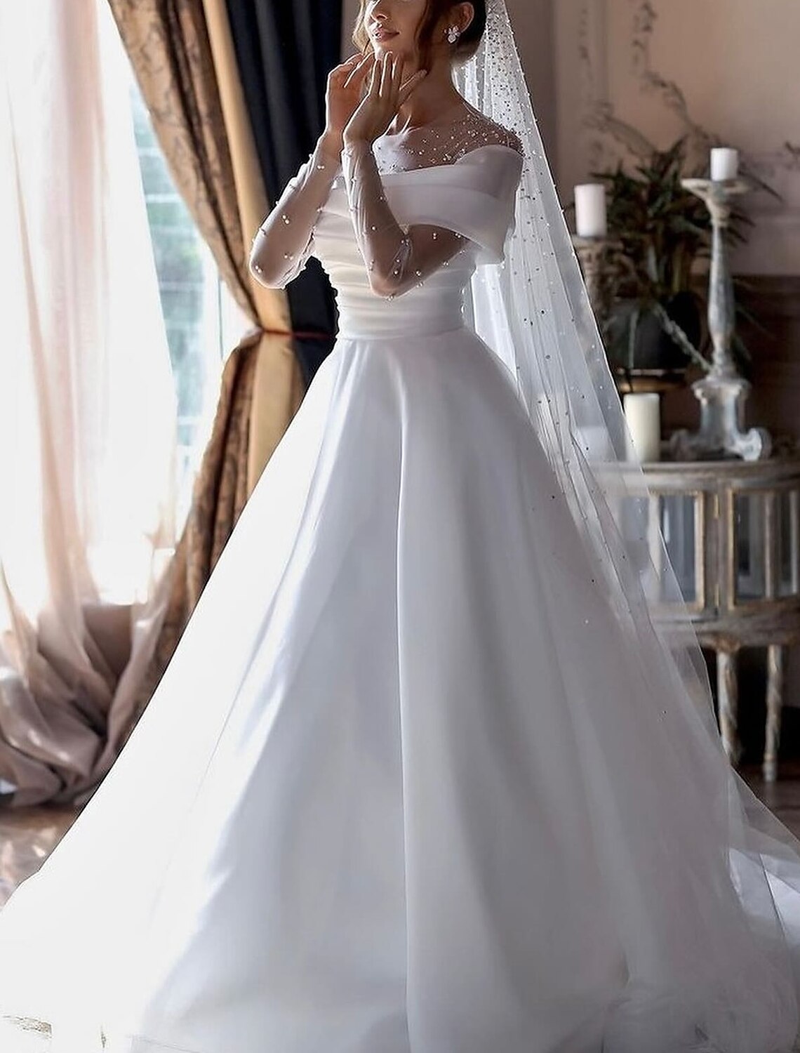 Close-up of the illusion neckline and long sleeve detail on the wedding dress.