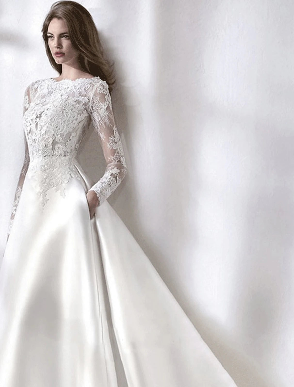 Full view of an A-Line satin wedding gown with illusion neck and long sleeves.