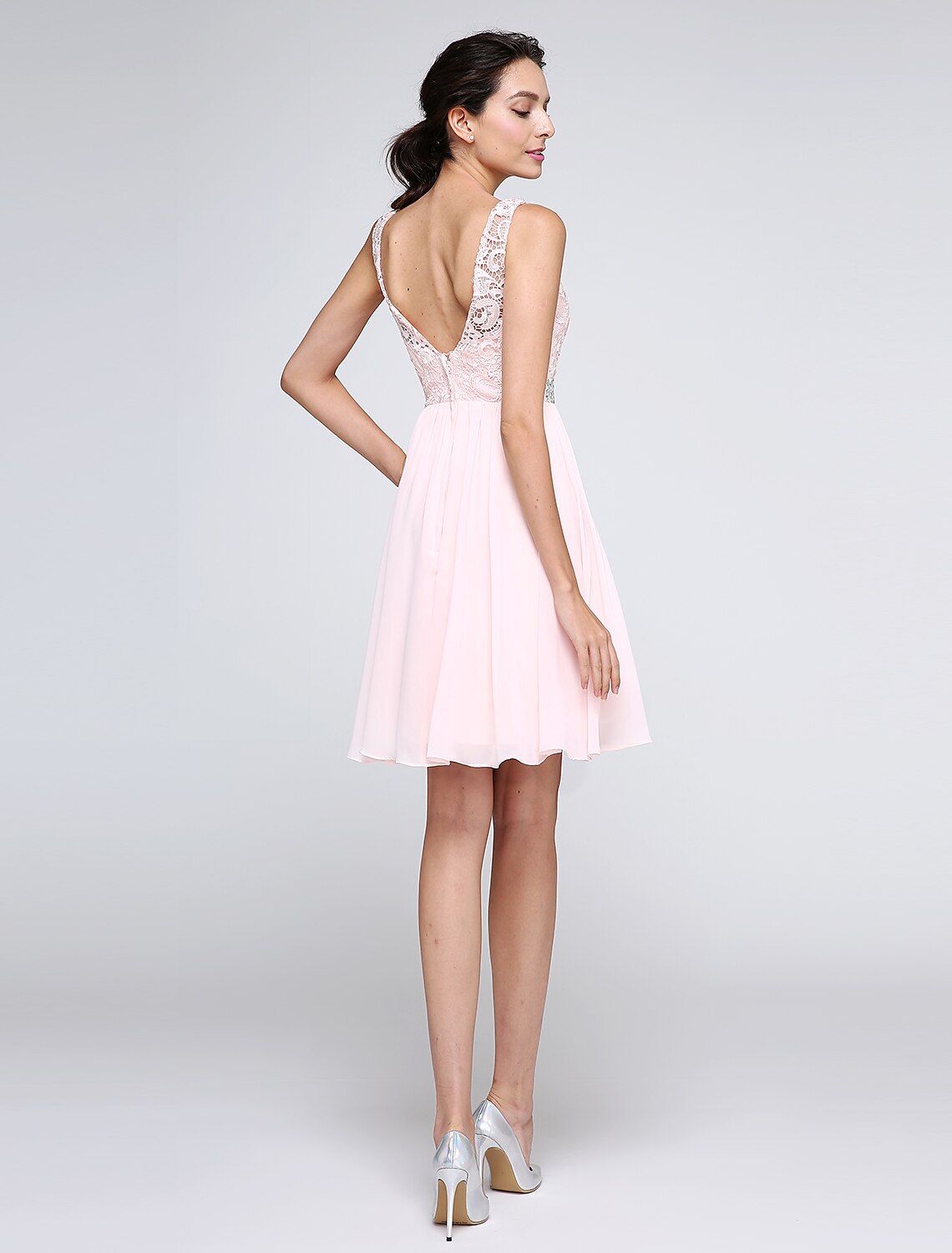 Back view of a pink A-line cocktail dress featuring a V-back, low-back design, and crystal details.