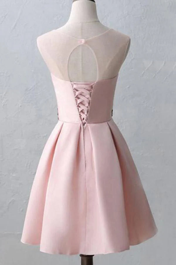 Model wearing a pink A-line short homecoming dress with illusion scoop neck.