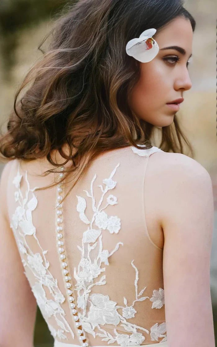 Back view of the sleeveless A-line wedding dress with intricate appliques.