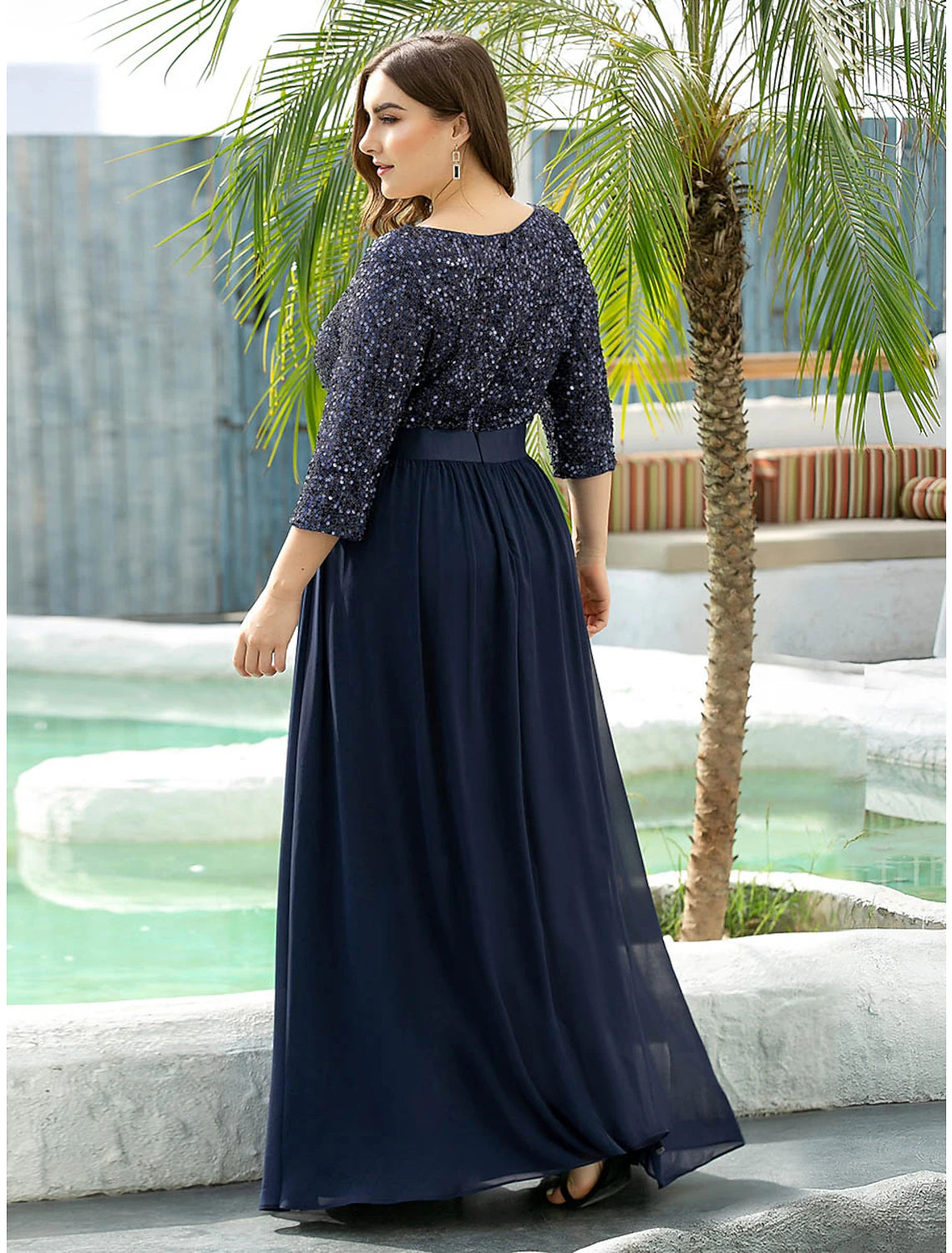 Woman posing in a sophisticated A-line sequined gown, suitable for fall events.