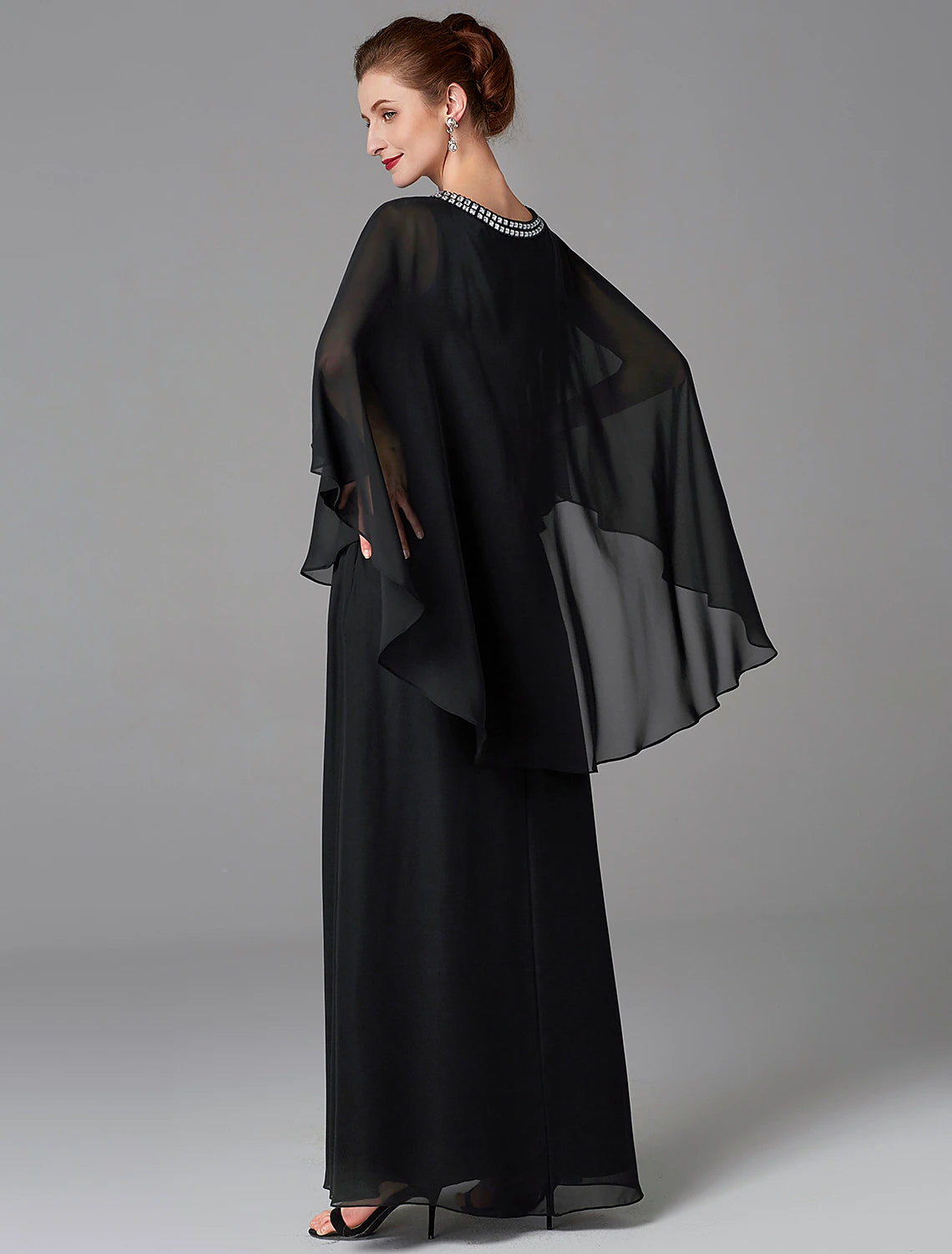Side view of the woman in the A-line mother of the bride gown, highlighting the cape detail.