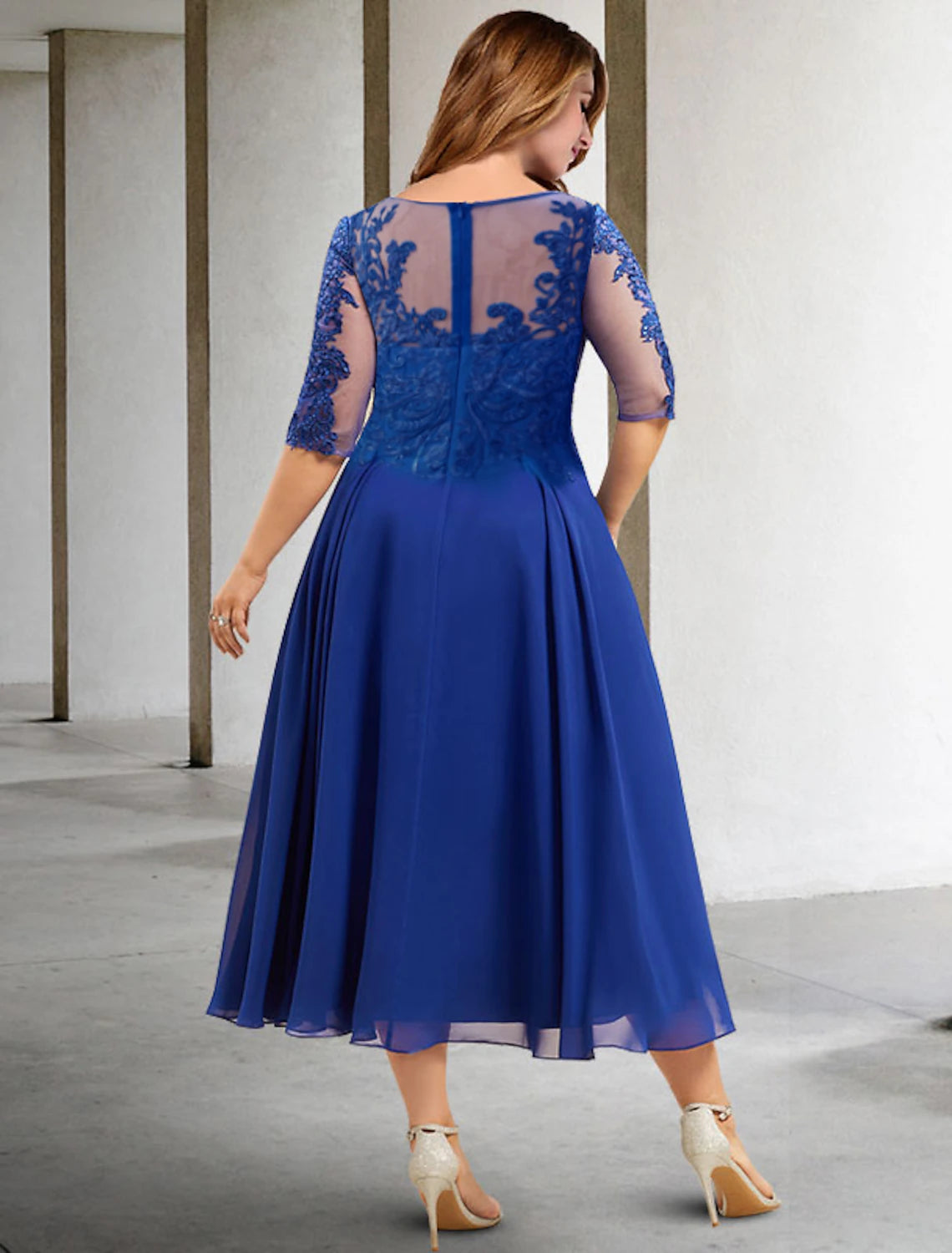 Back view of elegant plus size tea length dress with pleats and sequin details.