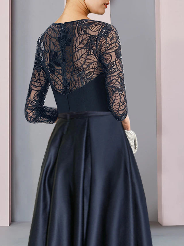 Back view of the A-line dress showing asymmetrical hem and pleated satin fabric.