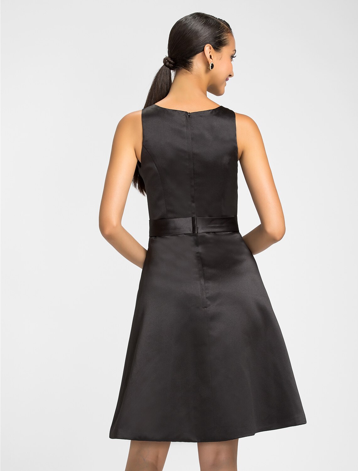 Detail of the ribbon accent on the knee-length satin bridesmaid dress.