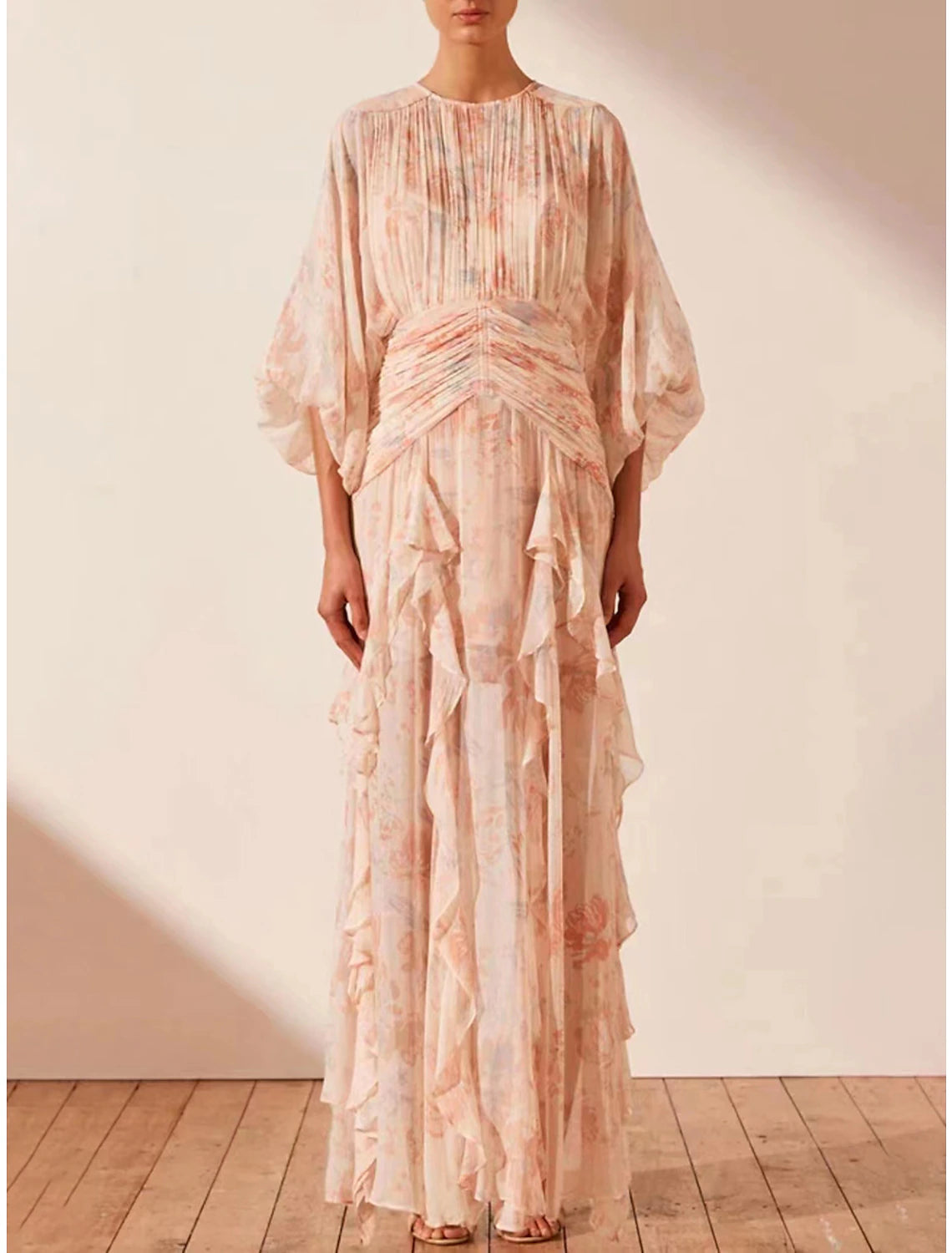 Woman wearing an A-line floral maxi dress, side view, showcasing ruffle details.