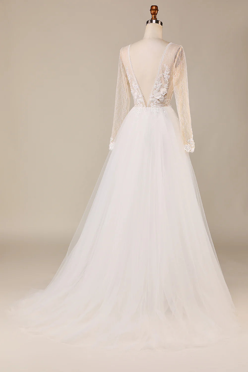 Back view of an ivory bridal gown featuring long lace sleeves and a flowing tulle train.