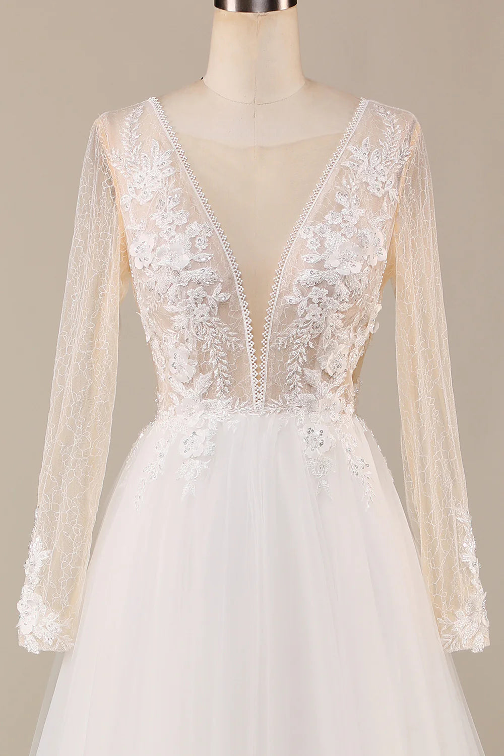 Close-up of intricate lace detailing on the bodice and sleeves of an ivory wedding dress.