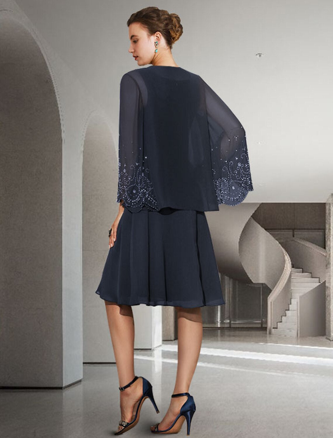 Close-up of the pleated and beaded details on the elegant chiffon Mother of the Bride dress.