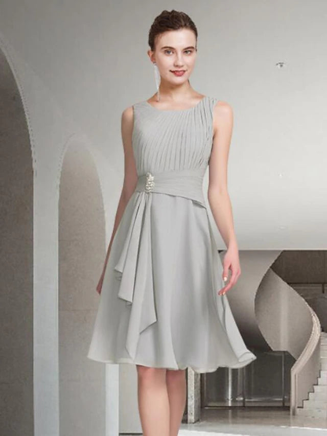 Woman in blue A-line two-piece dress, jewel neck, knee-length, walking pose.