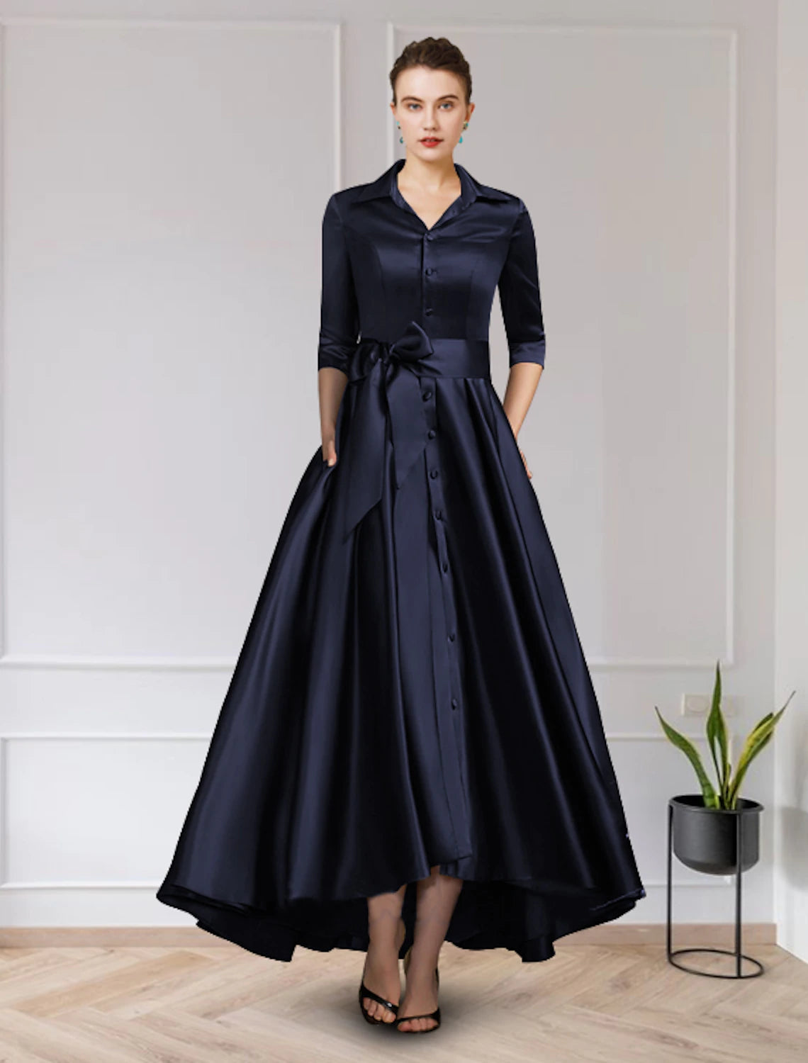 Woman wearing an elegant A-line high-low satin dress with a jewel neck and short sleeves.