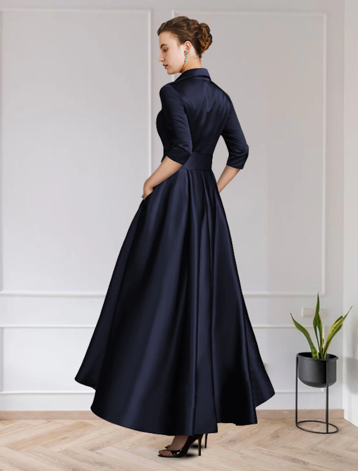 Back view of an A-line satin dress featuring a high-low hem, pleats, and appliques.