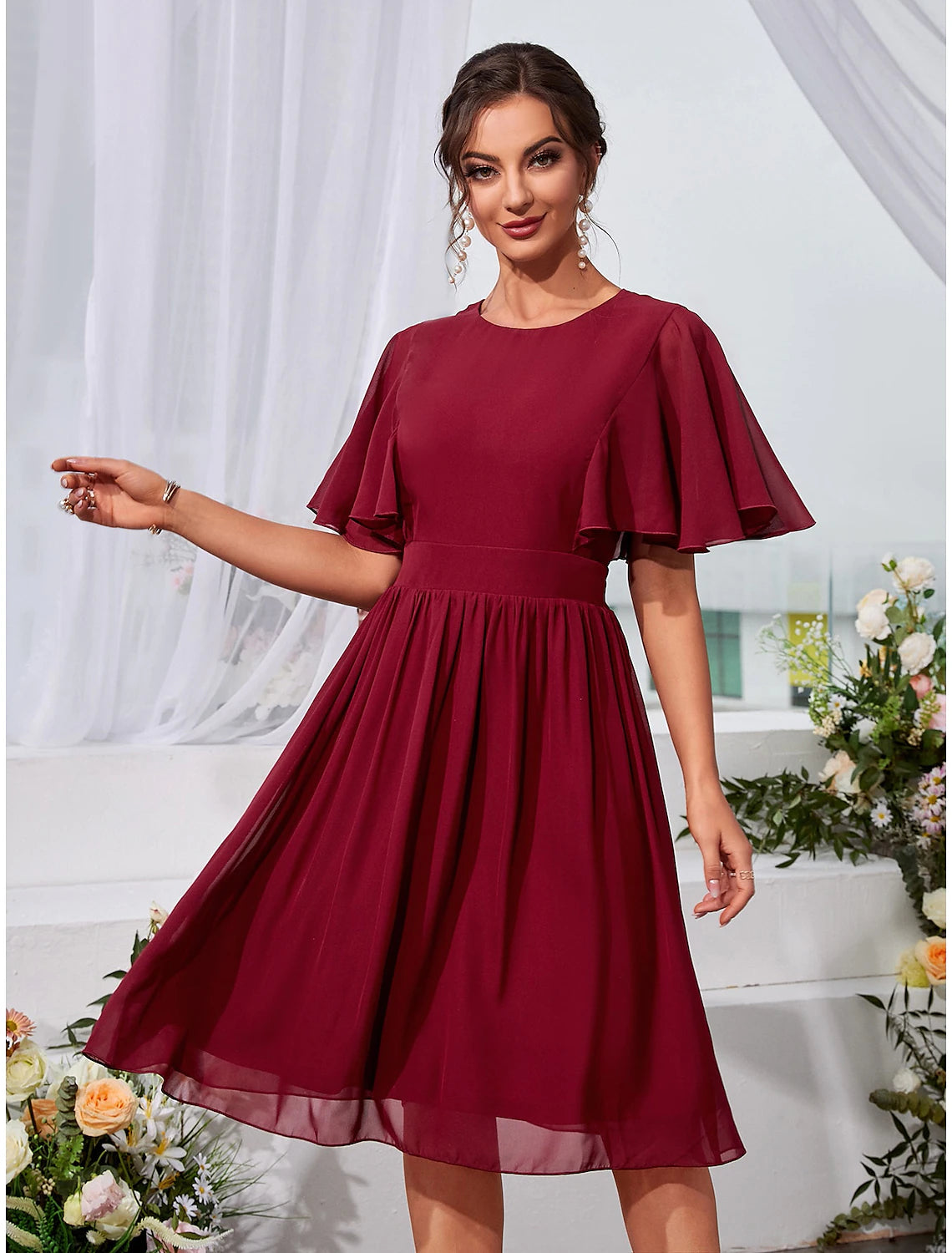 Elegant A-Line chiffon dress with jewel neck and short sleeves.
