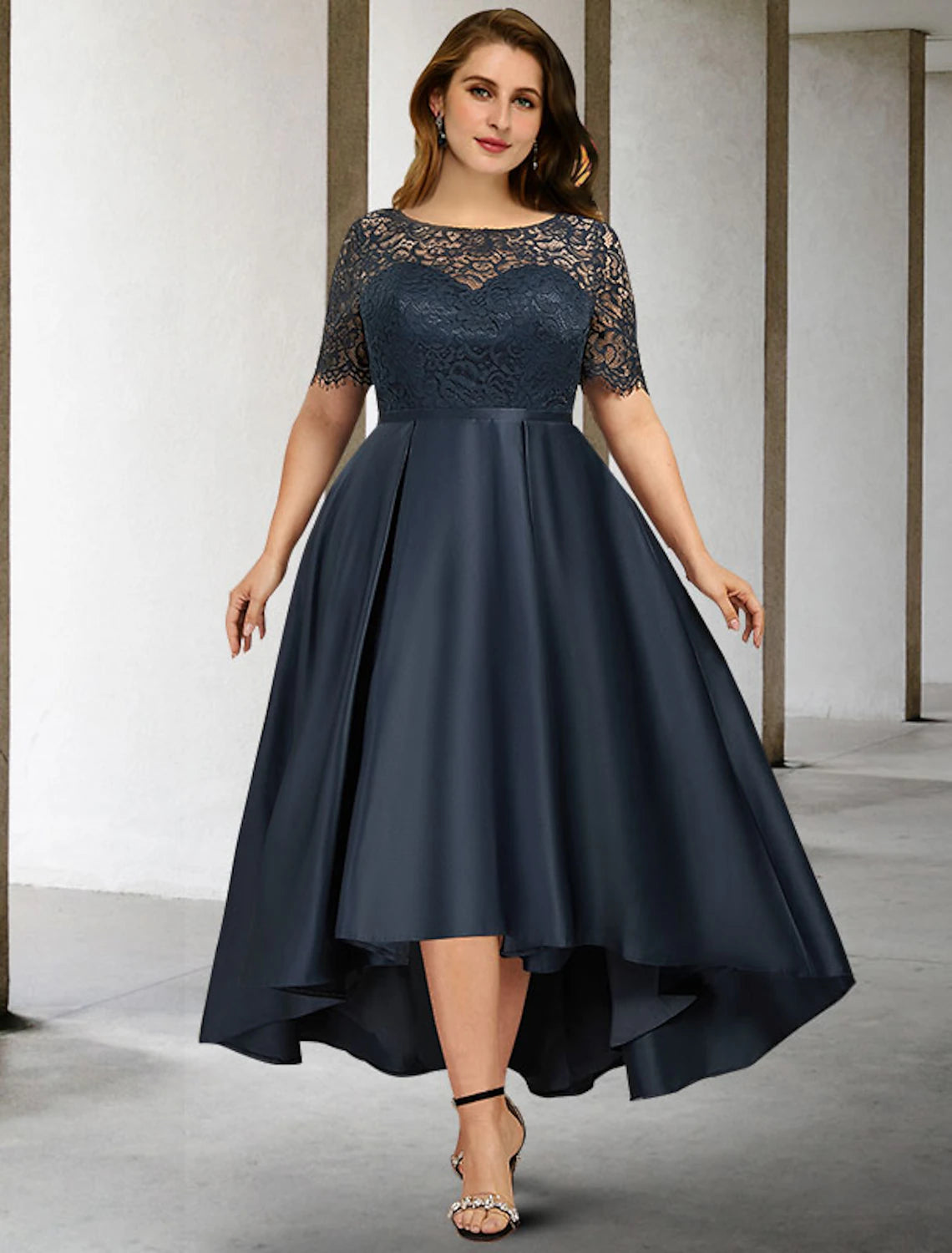Model wearing an elegant A-line plus size Mother of the Bride dress with a jewel neck and short sleeves.