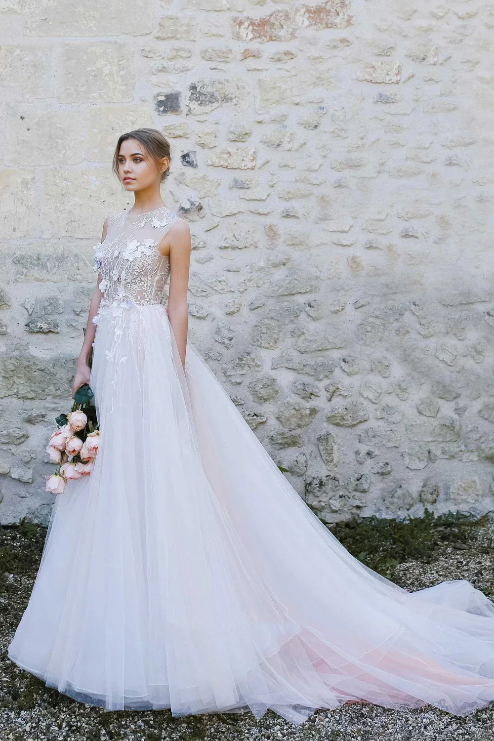 Model wearing an elegant A-Line tulle wedding dress with a jewel-neck and appliques.