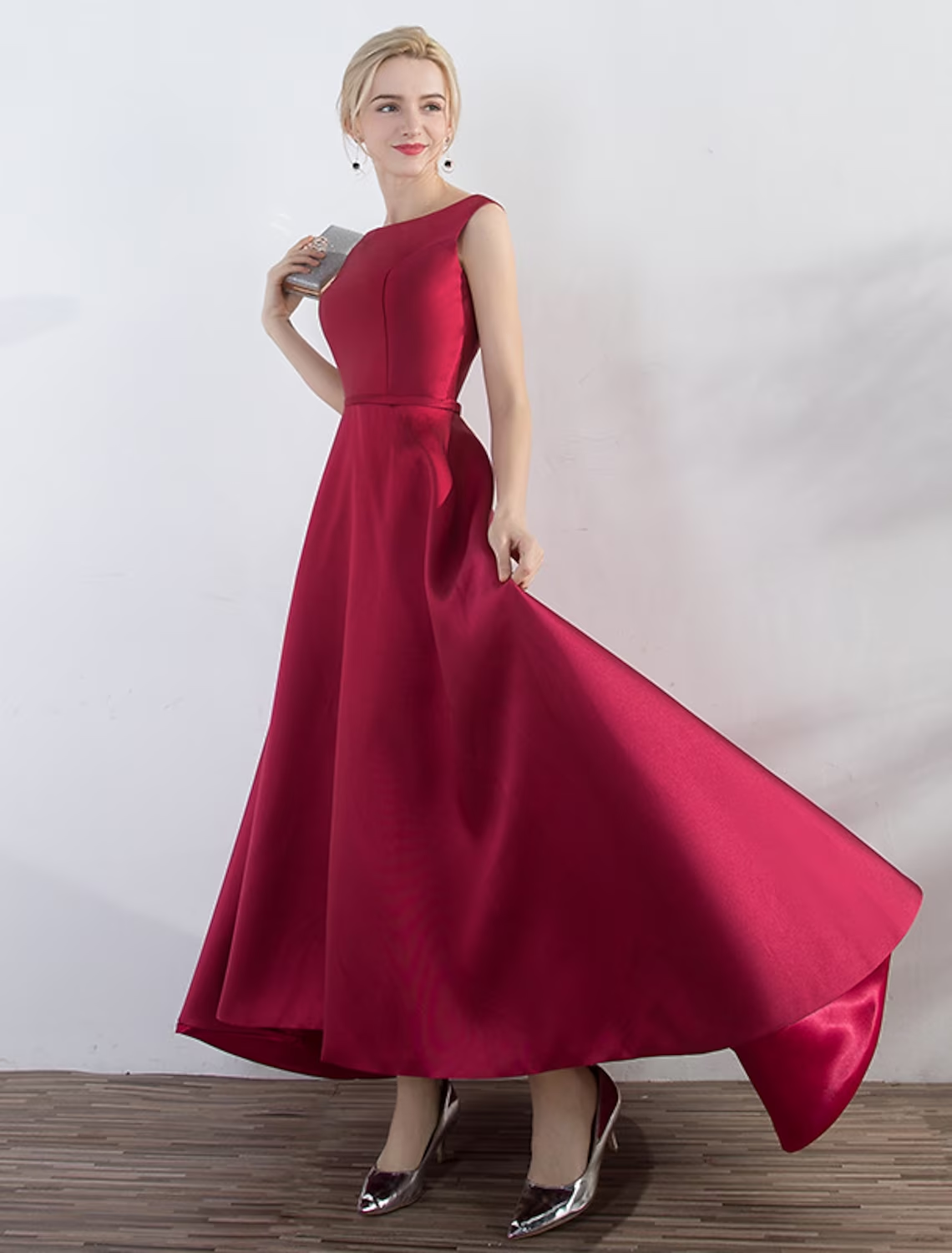 Woman wearing an elegant A-line jewel neck sleeveless satin evening gown.