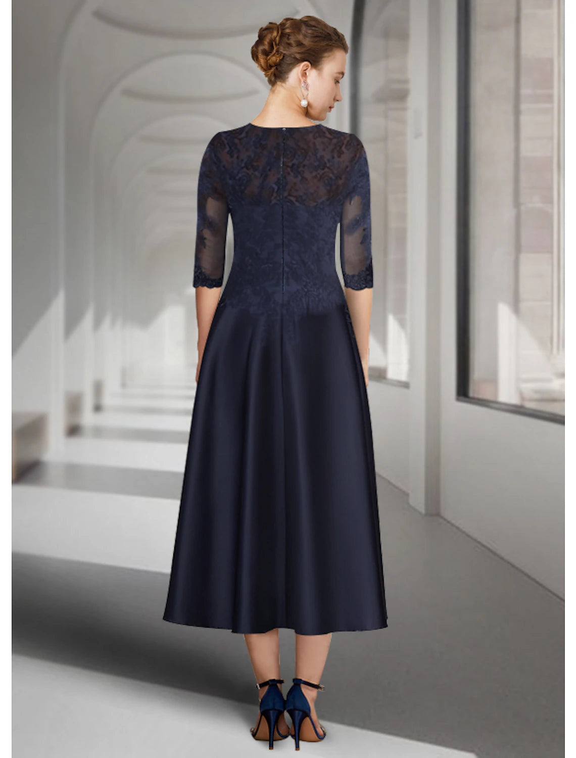 Dark blue tea length wedding guest dress featuring a jewel neck and delicate appliques.