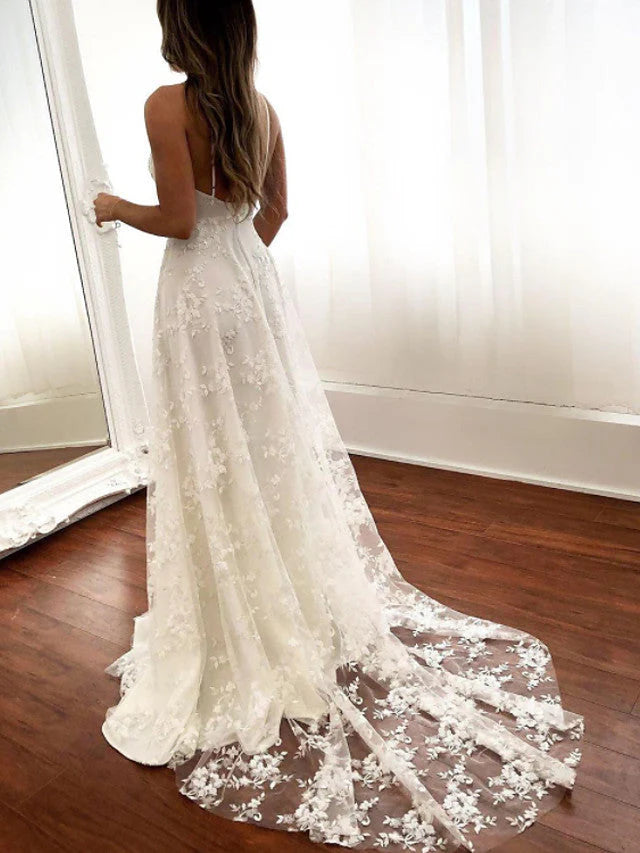 Back view of a bride in a backless A-line lace wedding gown.