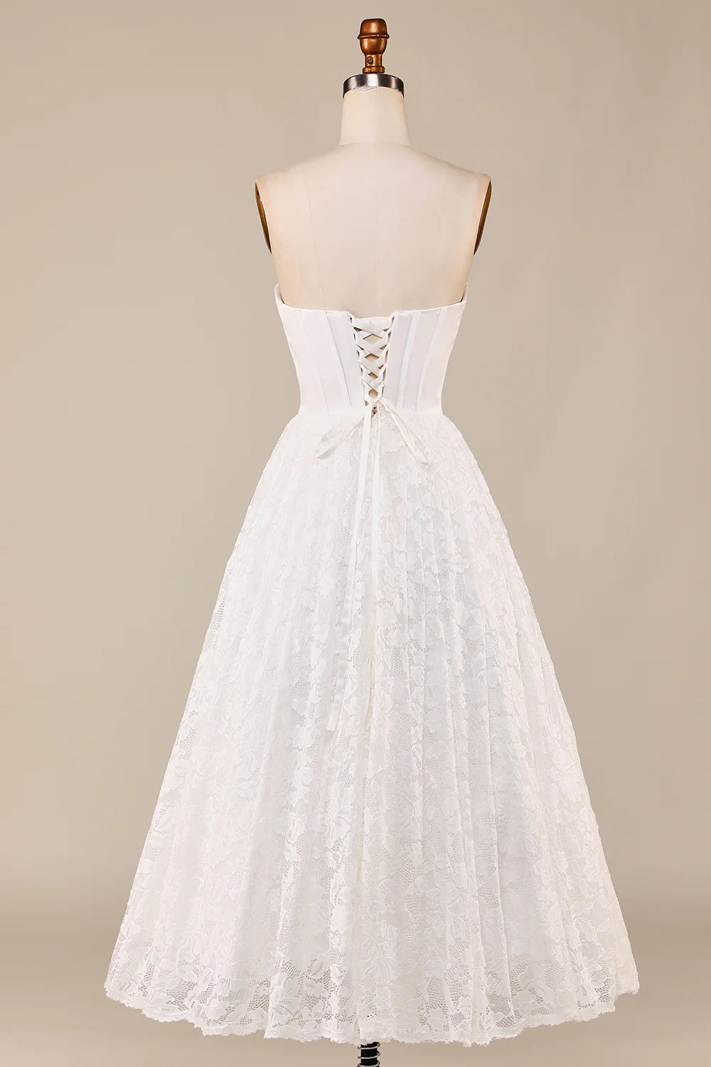 Close-up of the delicate lace and corset detailing on the ivory wedding dress.