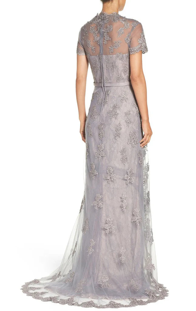 Side view of a woman in an ankle-length A-line lace dress, suitable for a wedding guest.